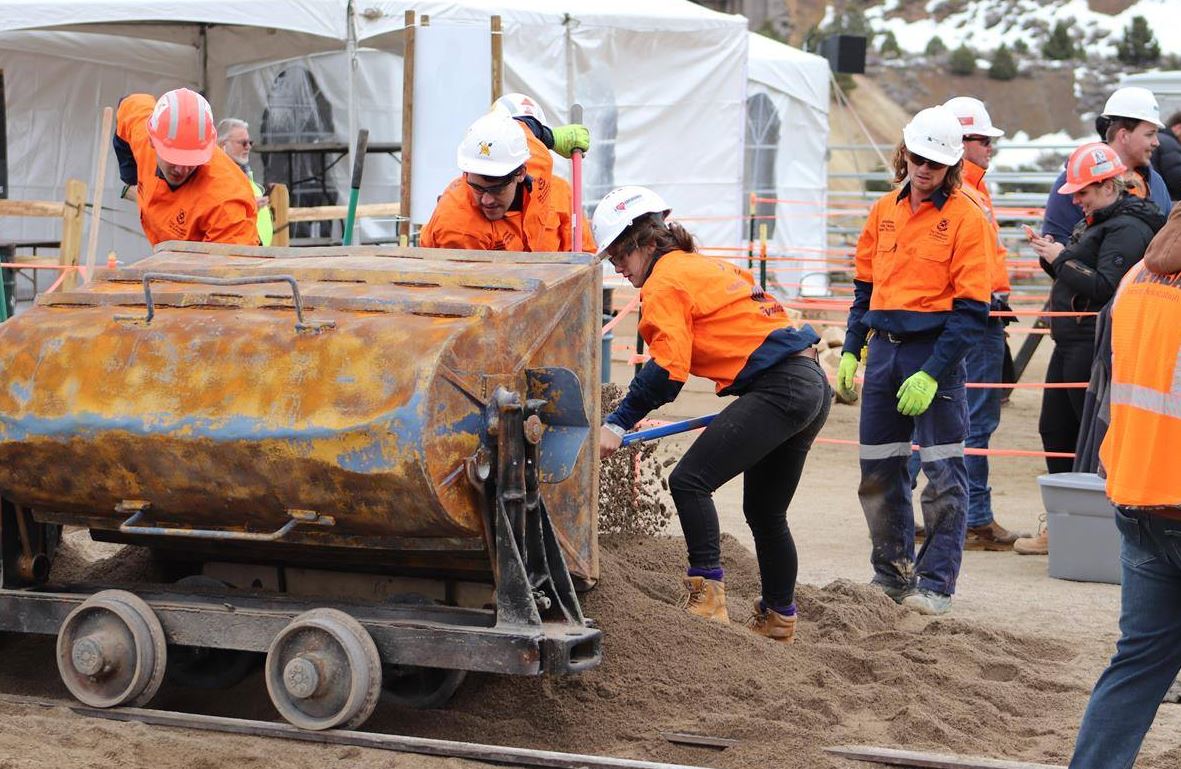 team members shovelling sand