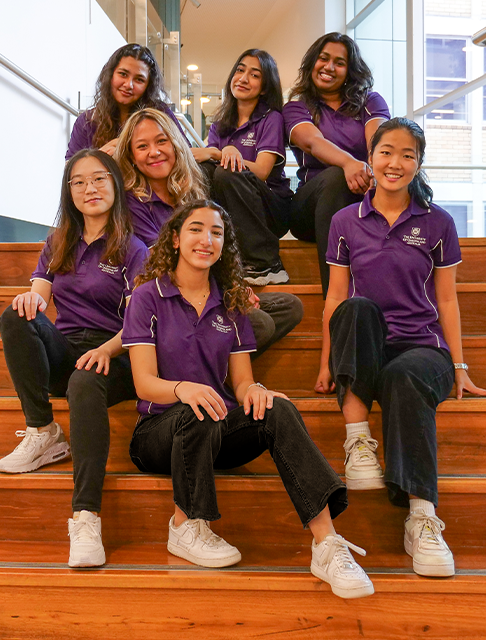 WE Student Leaders posing with a banner