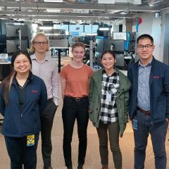 A group of engineers and high school students standing next to each other