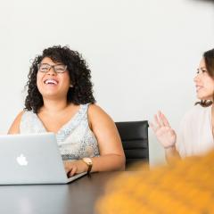 stock image: woman laughing with hands on laptop keyboard