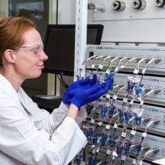 Dr Ruth Knibbe with a coin cell battery used for testing.