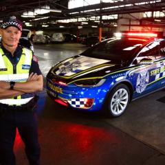 Victoria Police Inspector Stuart Bailey with the first all-electric vehicle in its operational fleet. 