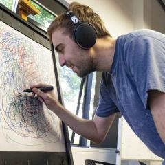 male person drawing on electronic board