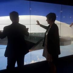 two people looking at and touching a wall sized screen