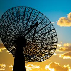 image of satellite dish against cloudy blue sky